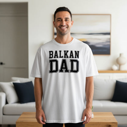 White t-shirt with "BALKAN DAD" text on chest, worn by a man.