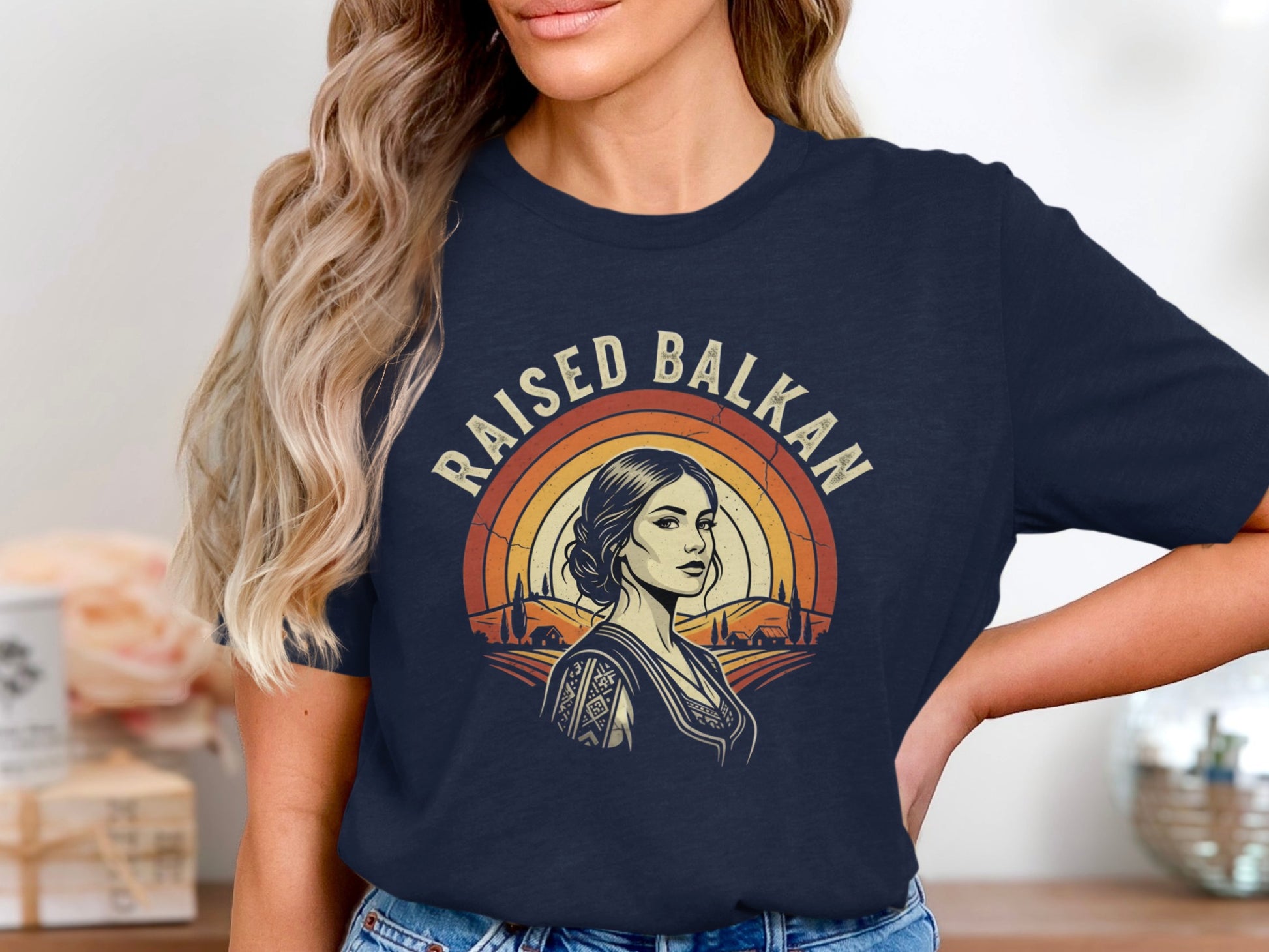 "Raised Balkan" text over woman in t-shirt with rural landscape.