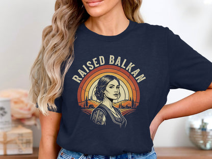 "Raised Balkan" text over woman in t-shirt with rural landscape.