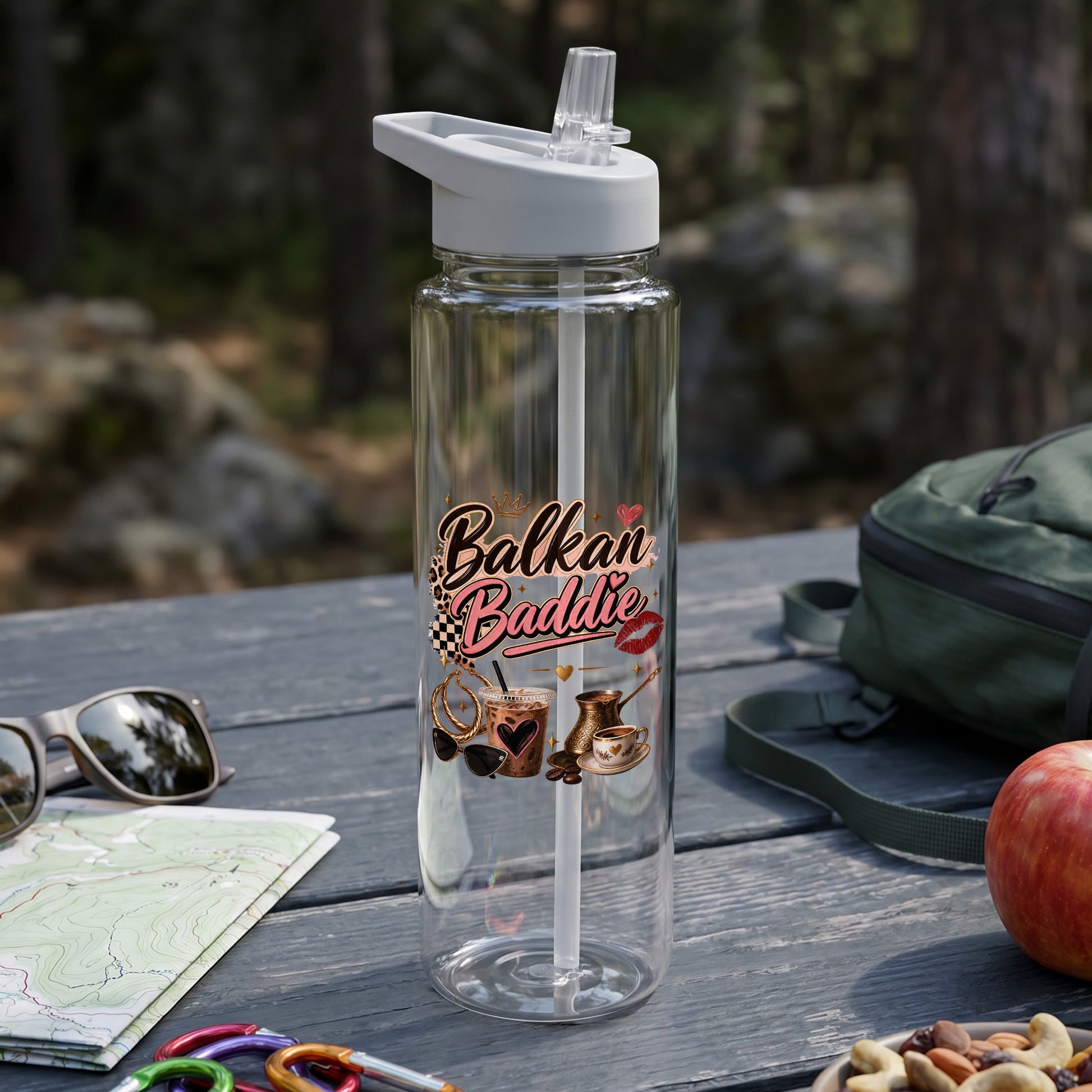 Clear water bottle with "Balkan Baddie" text and themed graphics on a picnic table.