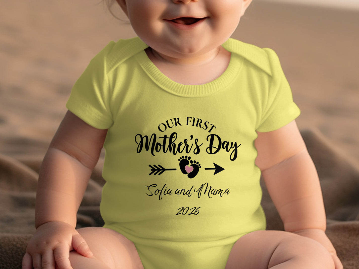 Baby in yellow onesie with "Our First Mother's Day" text.
