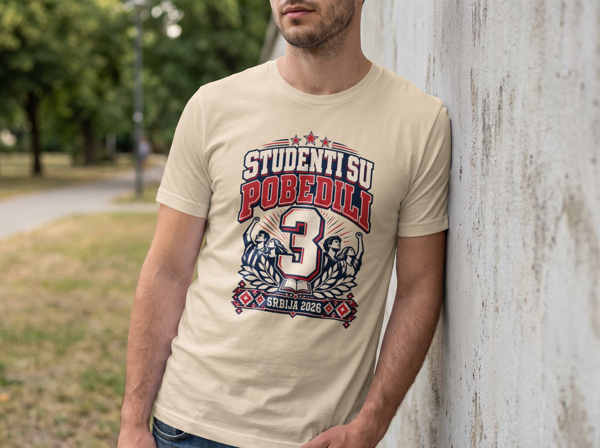 A man wearing a beige t-shirt featuring a blue and red graphic with the text STUDENTS SU POBEDILI.