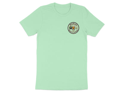 Mint t-shirt with a circular logo featuring a glass and olives, "Rakija" and "Quality Control".