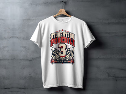 White t-shirt hanging on a textured wall, featuring a red and blue graphic with students and text.