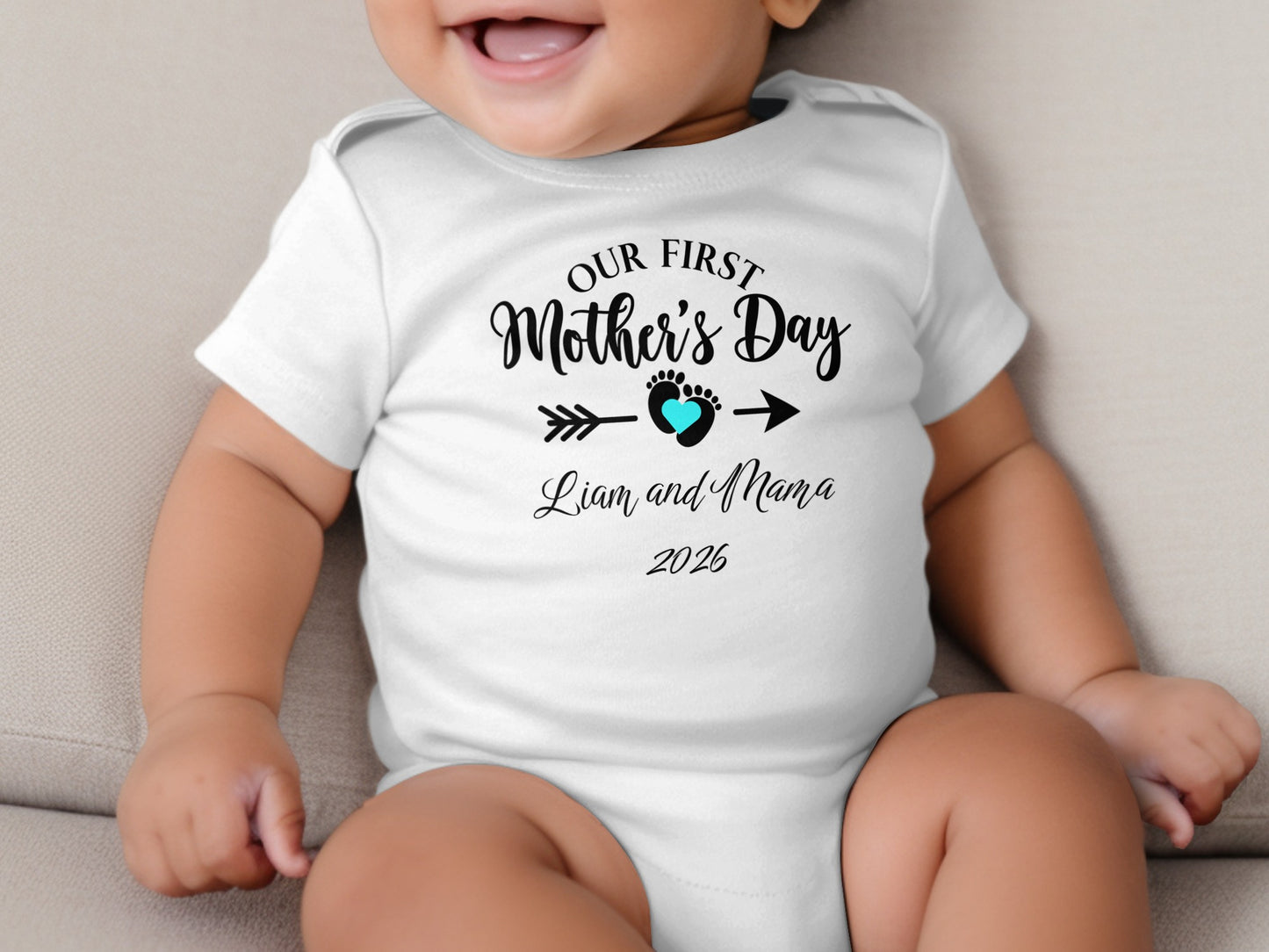Baby's white bodysuit with "Our First Mother's Day Liam and Mama 2026" text.