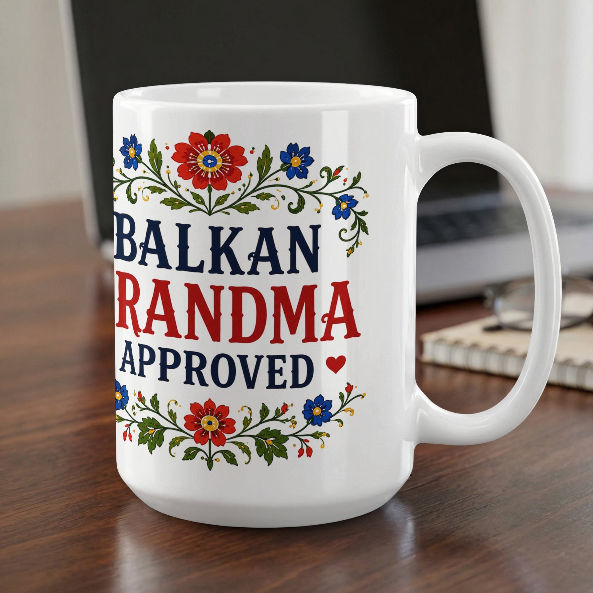 White mug with "BALKAN GRANDMA APPROVED" text and floral accents.