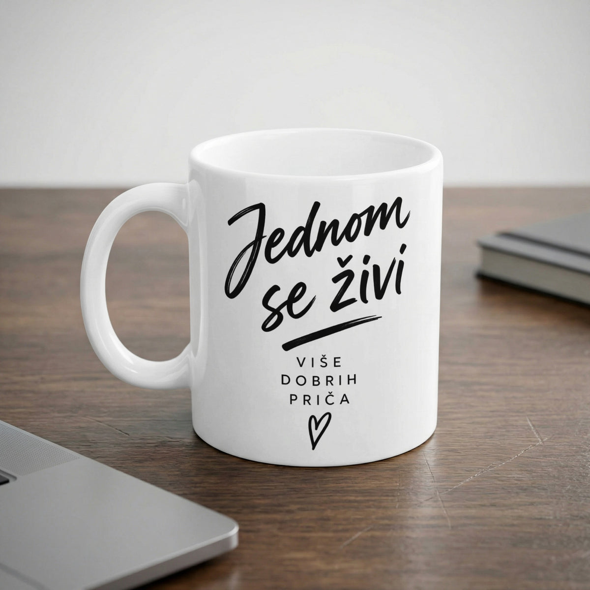 White mug with black text reading "Jednom se živi" and "VIŠE DOBRIH PRIČA".