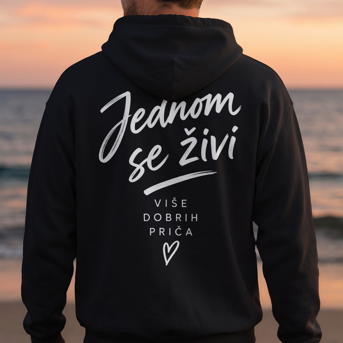Black hoodie with white text: "Jednom se živi" and "više dobrih priča" with a heart.