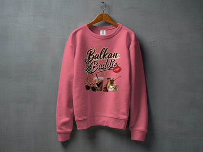 Pink sweatshirt with "Balkan Baddie" text and coffee, sunglasses, and lips graphic.