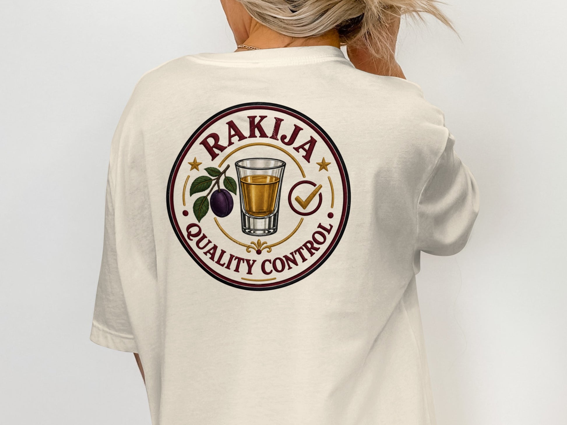 Rakija Quality Control circular logo with a shot glass and plum on a t-shirt.