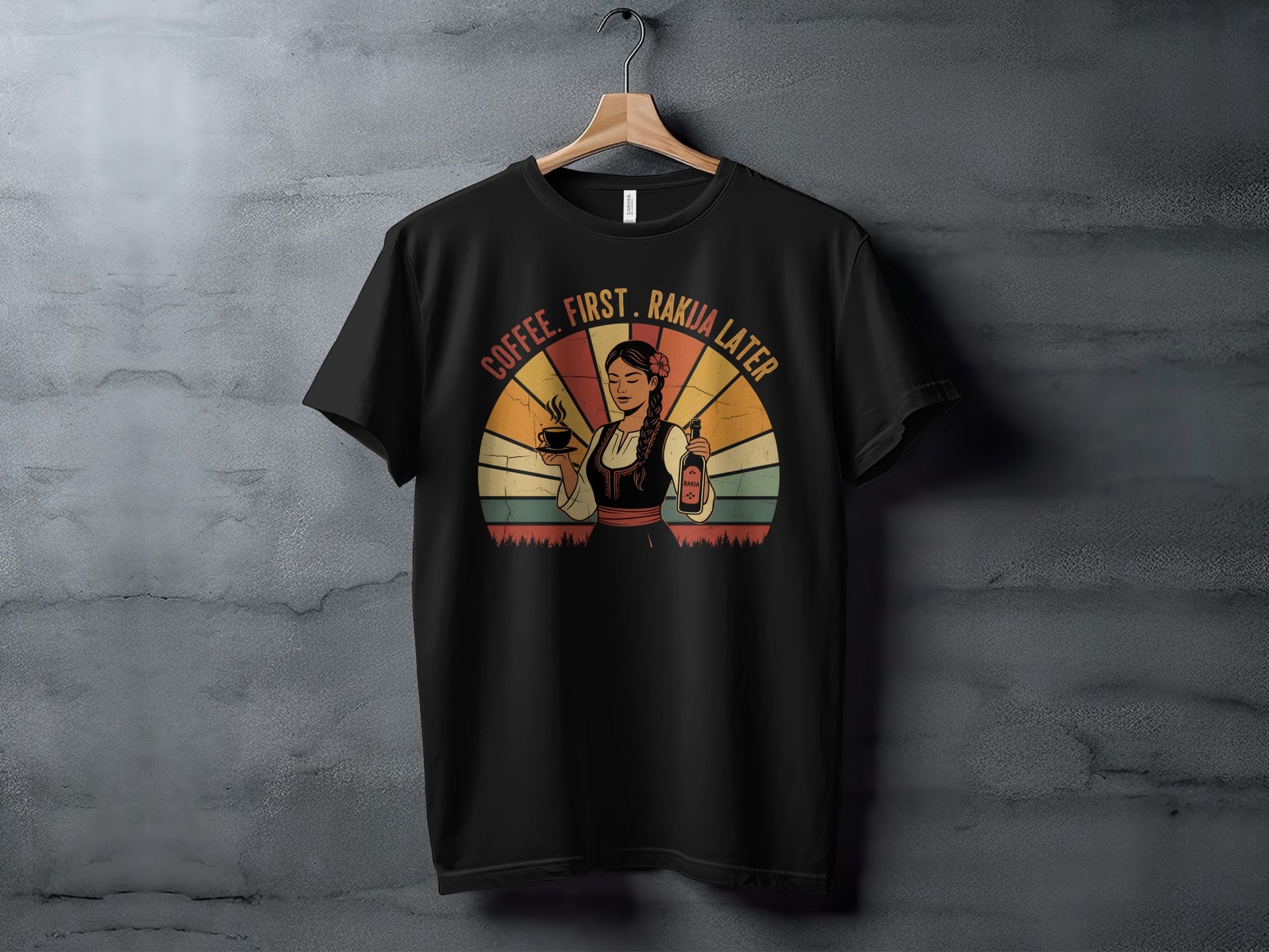Black t-shirt with "Coffee, First. Rakua Later" text and woman holding coffee and raku bottle.