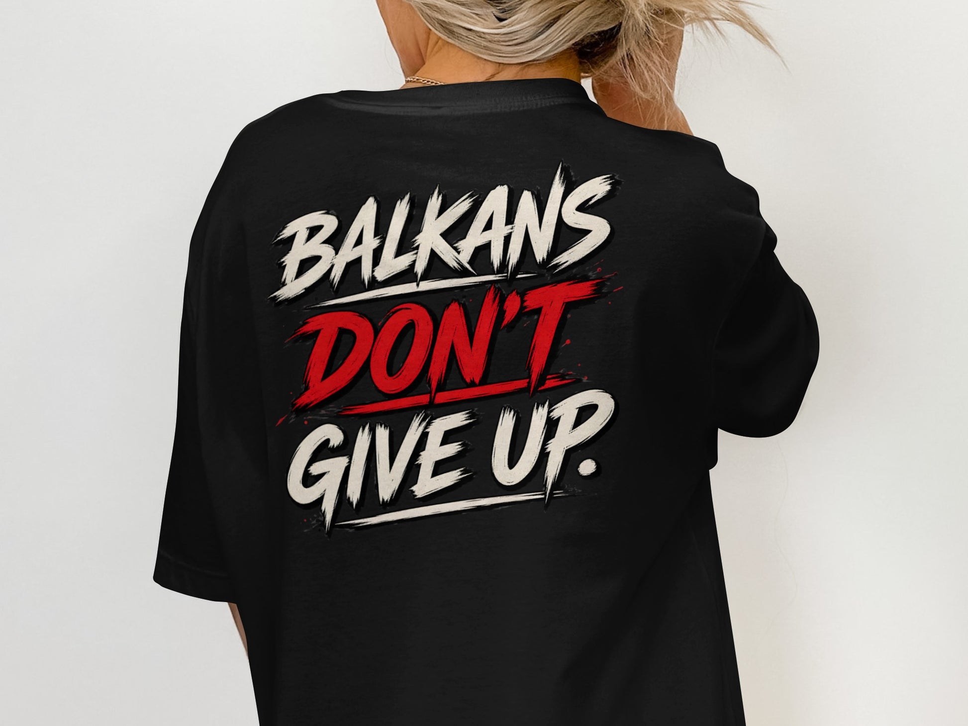 Black t-shirt with "BALKANS DON'T GIVE UP." text design on the back.