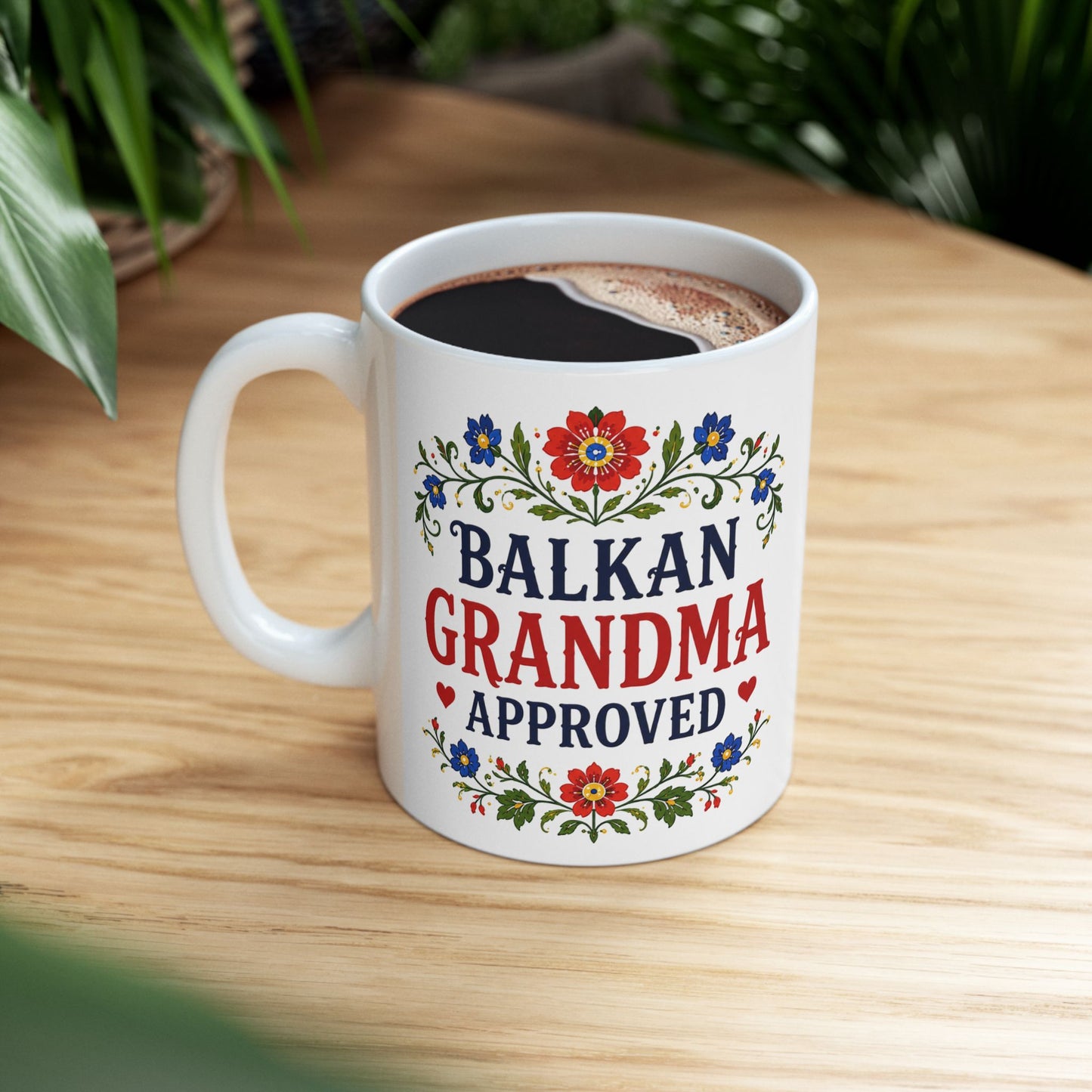 White mug with "Balkan Grandma Approved" text and floral design.