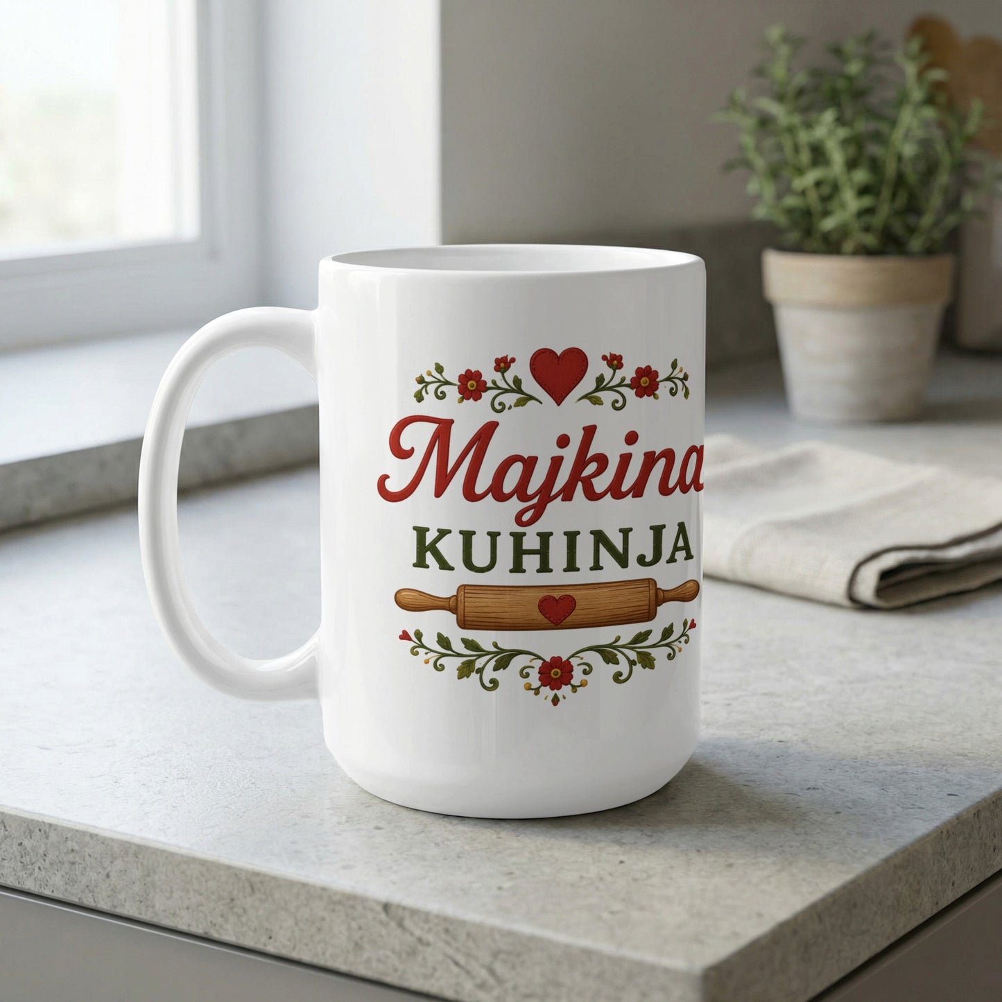White mug with "Majkina KUHINJA" text, heart, and rolling pin graphic.