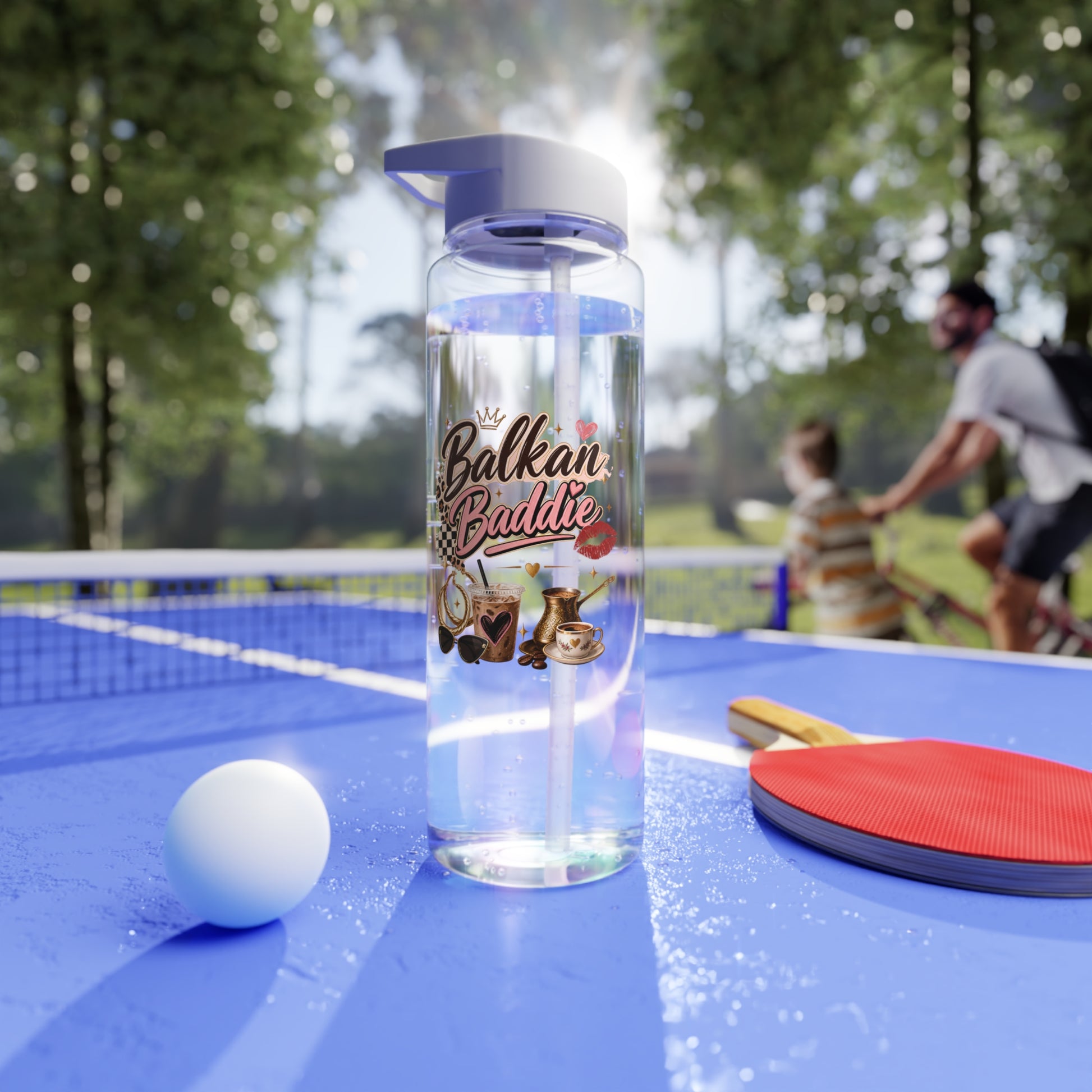 Clear water bottle with "Balkan Baddie" text and coffee graphics on ping pong table.