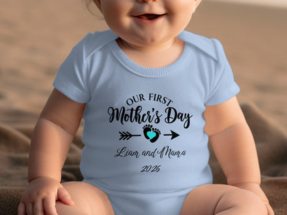 Light blue baby onesie with "Our First Mother's Day" text and heart.
