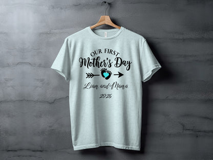 Light blue t-shirt with "Our First Mother's Day" text and baby footprint design.