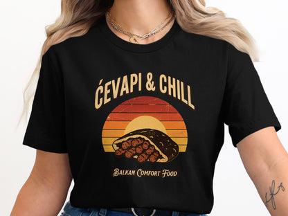 Black t-shirt with graphic featuring cevapi, "Čevapi & Chill", and "Balkan Comfort Food".