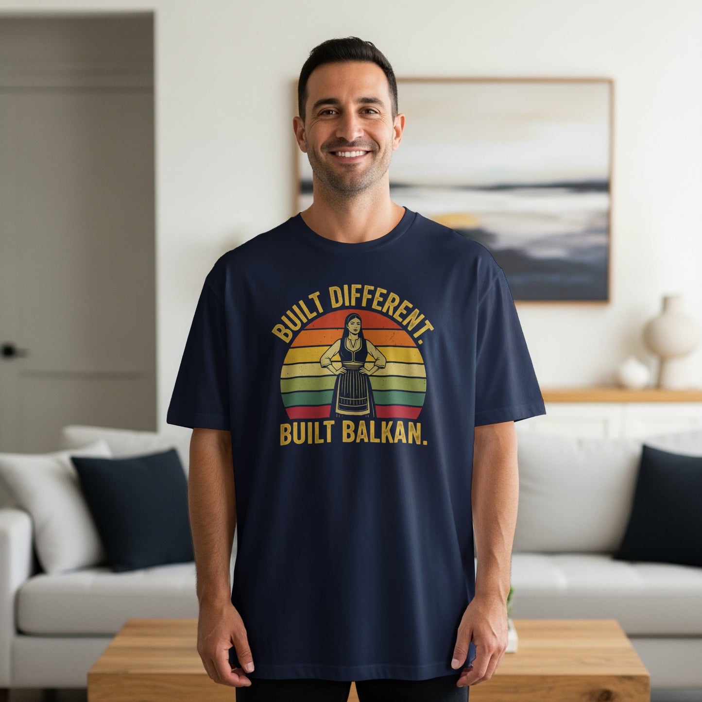 Man wearing navy t-shirt with "Built Different. Built Balkan." text and retro sun graphic.