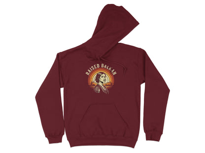 Burgundy hoodie with "Raised Balkan" text and a woman in front of a sunset landscape.