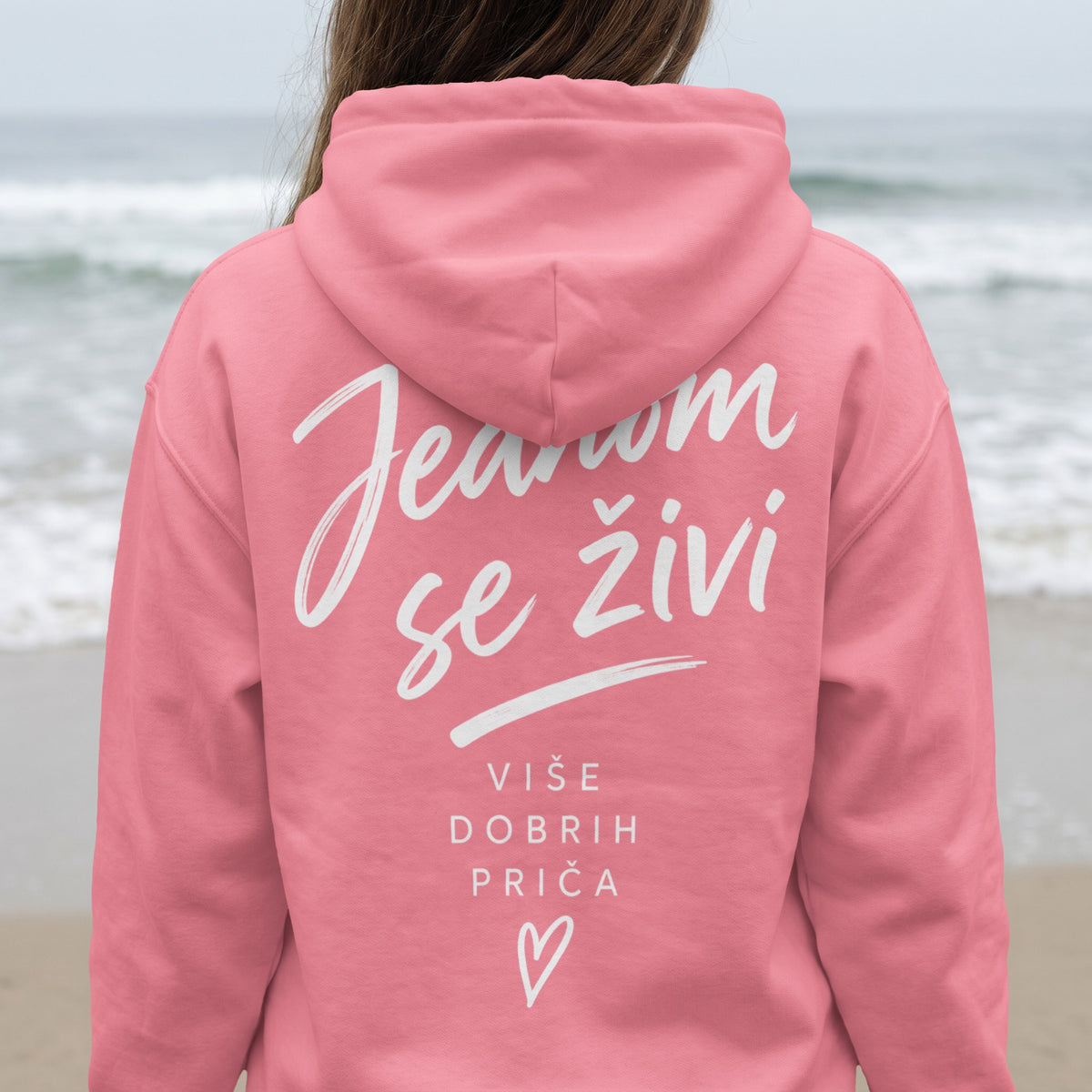 Pink hoodie with white text "Jesnom se živi" and "Više dobrih priča" with heart.