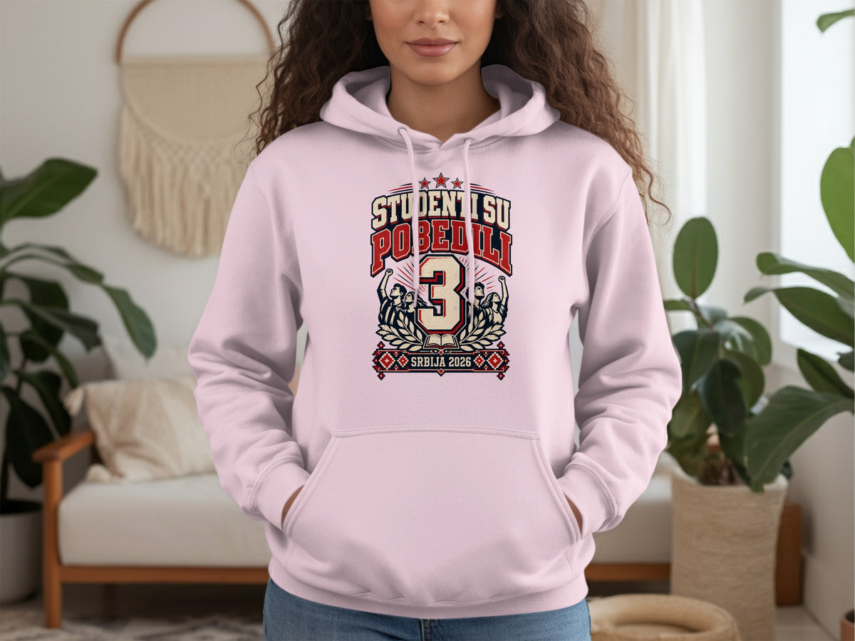 A person wearing a light pink hooded sweatshirt with a red and blue graphic design on the chest.