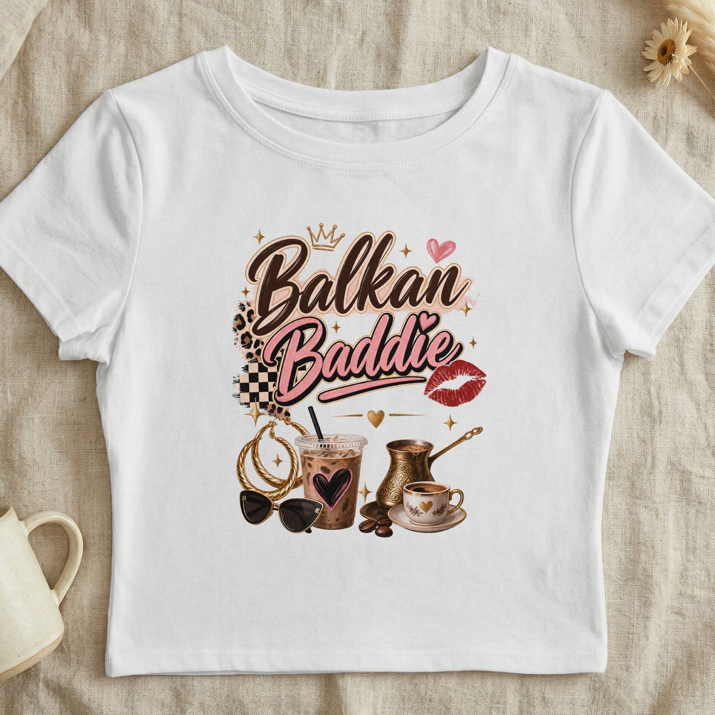 White t-shirt with "Balkan Baddie" text, crown, heart, and coffee cup graphic.