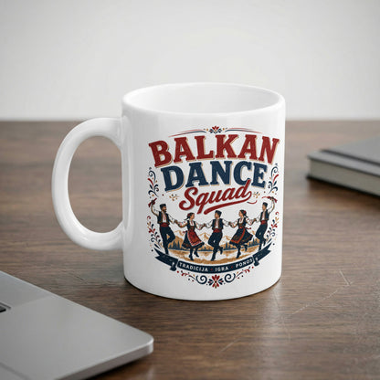White mug with "Balkan Dance Squad" text and dancing figures in traditional attire.