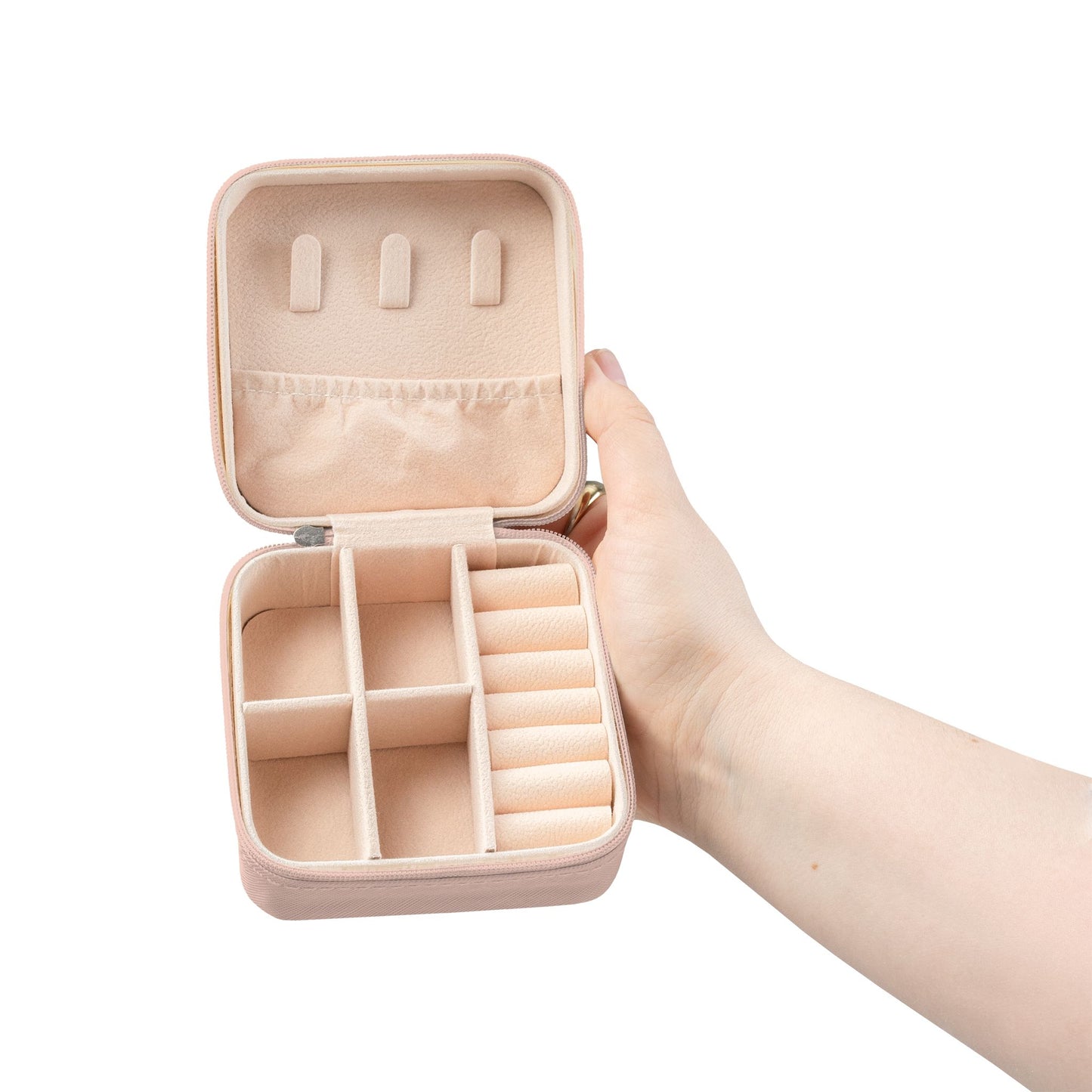 Pink jewelry box with open compartments, held by a person's hand.