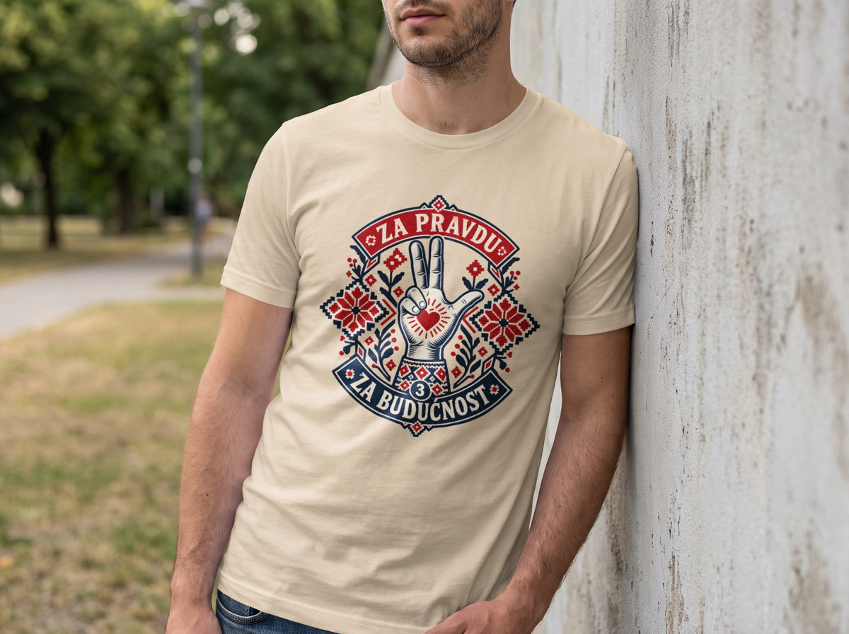 A man leaning against a concrete wall wearing a cream t-shirt with a graphic design and text.