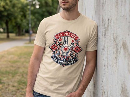 A man leaning against a concrete wall wearing a cream t-shirt with a graphic design and text.