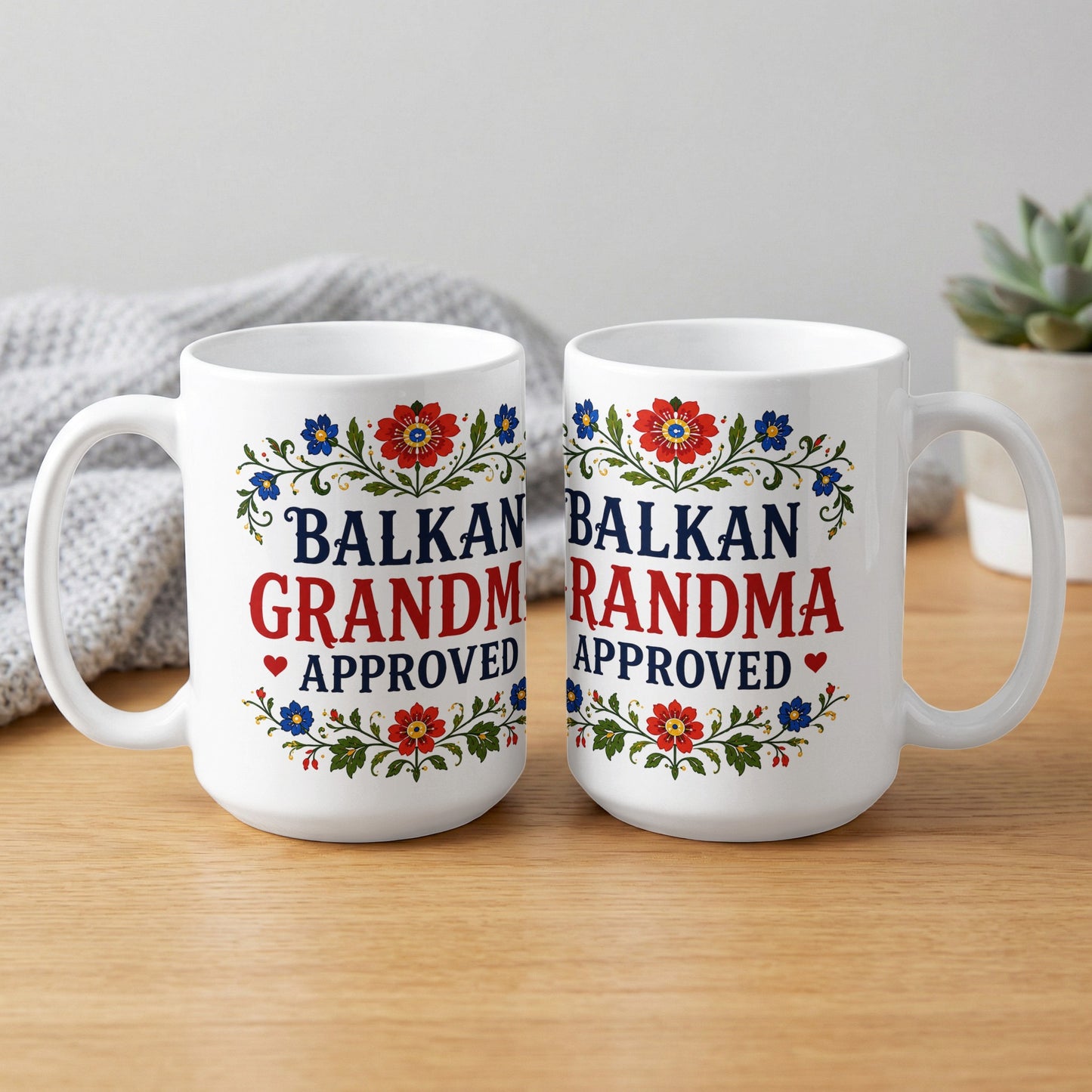 Two white mugs with red and blue floral borders and the text "BALKAN GRANDMA APPROVED."