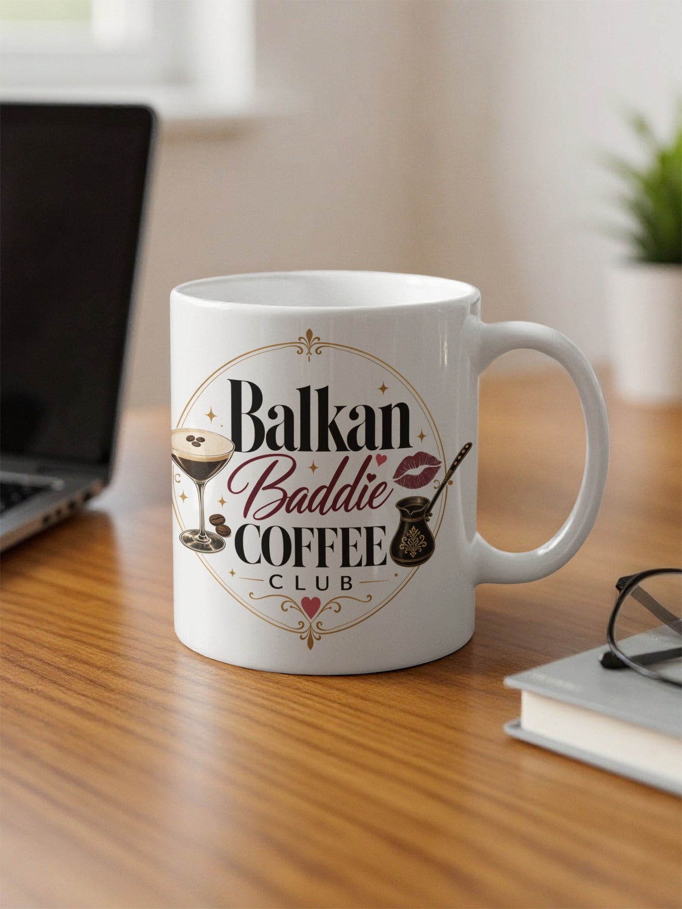 White mug with "Balkan Baddie Coffee Club" text and coffee-themed graphics.