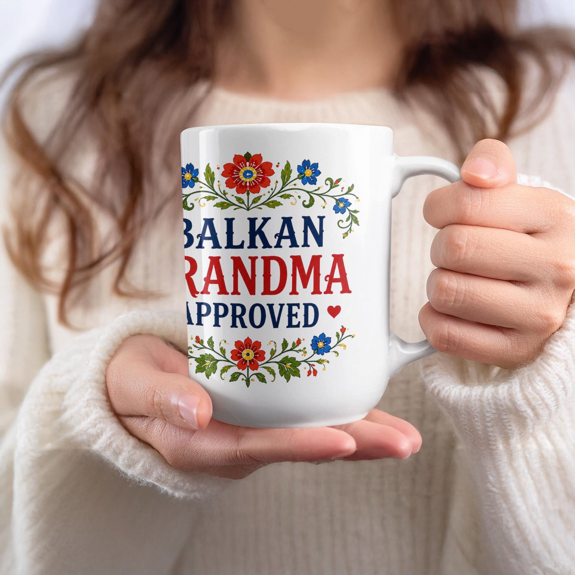White mug with "BALKAN GRANDMA APPROVED" text and floral design.