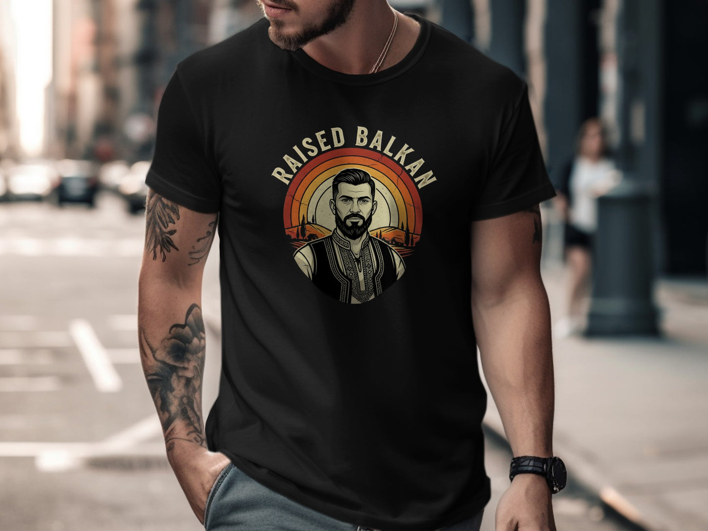Black t-shirt with "Raised Balkan" text and a man in traditional clothing design.