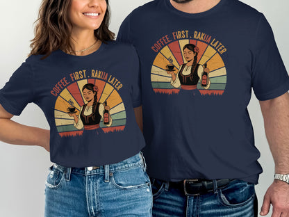 Two people wearing navy t-shirts with retro graphic of woman holding coffee and text "COFFEE. FIRST. RAKIJA LATER."