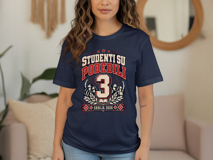 A person wears a dark blue t-shirt printed with the text "STUDENTI SU POBEDILI 3 SRBIJA 2026".