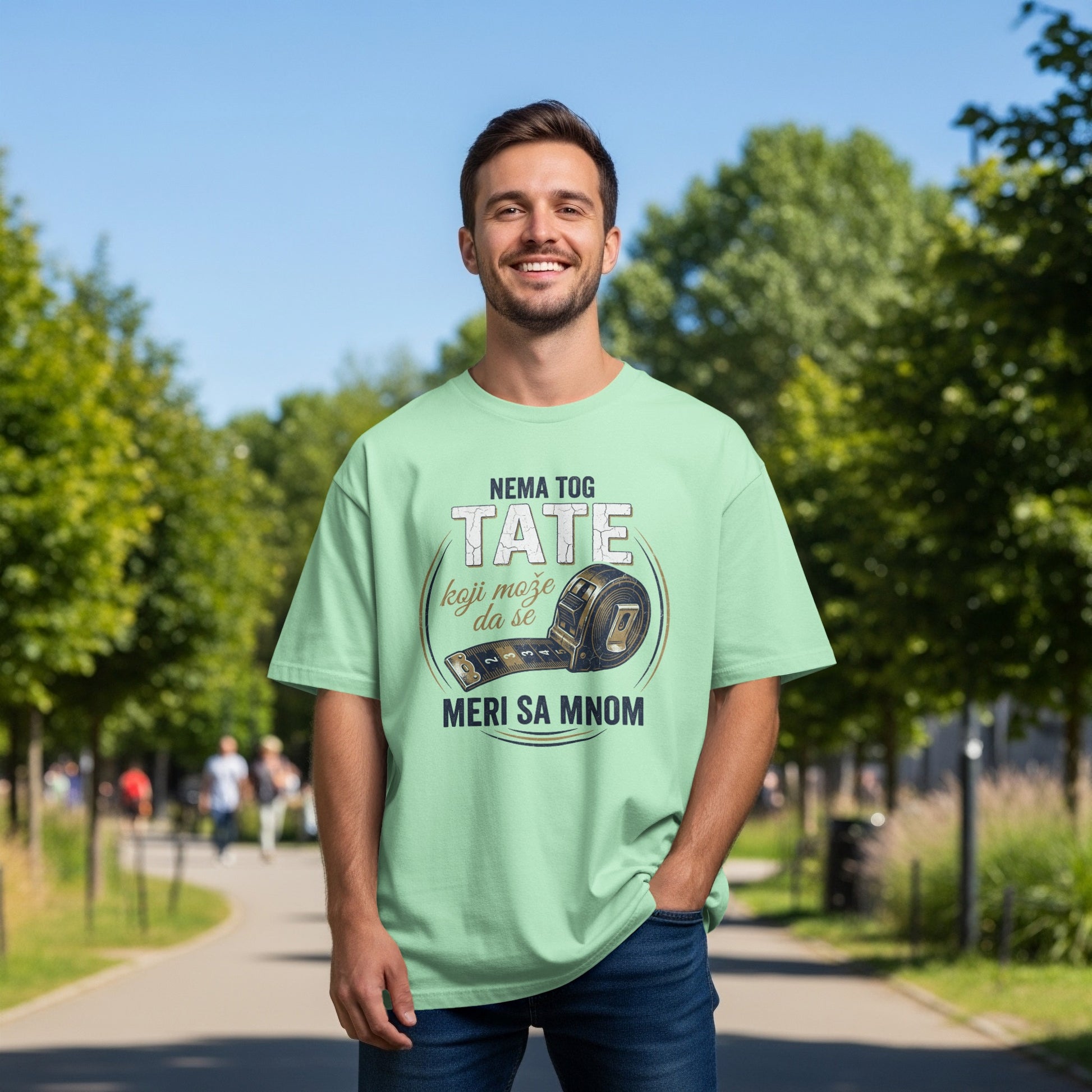 Man wearing light green t-shirt with "NEMA TOG TATE" and measuring tape graphic.