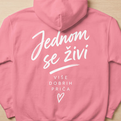 Pink hoodie with white text "Jednom se živi više dobrih priča" and a heart.