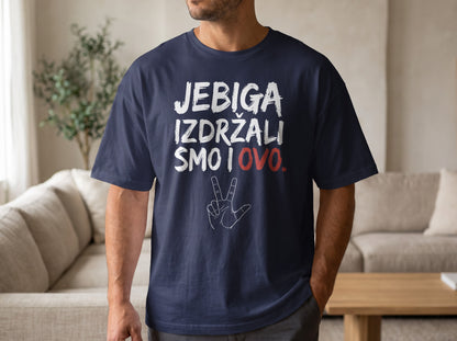 A man wearing a dark blue t-shirt printed with white text reading JEBIGA IZDRŽALI SMO I OVO and a hand graphic.