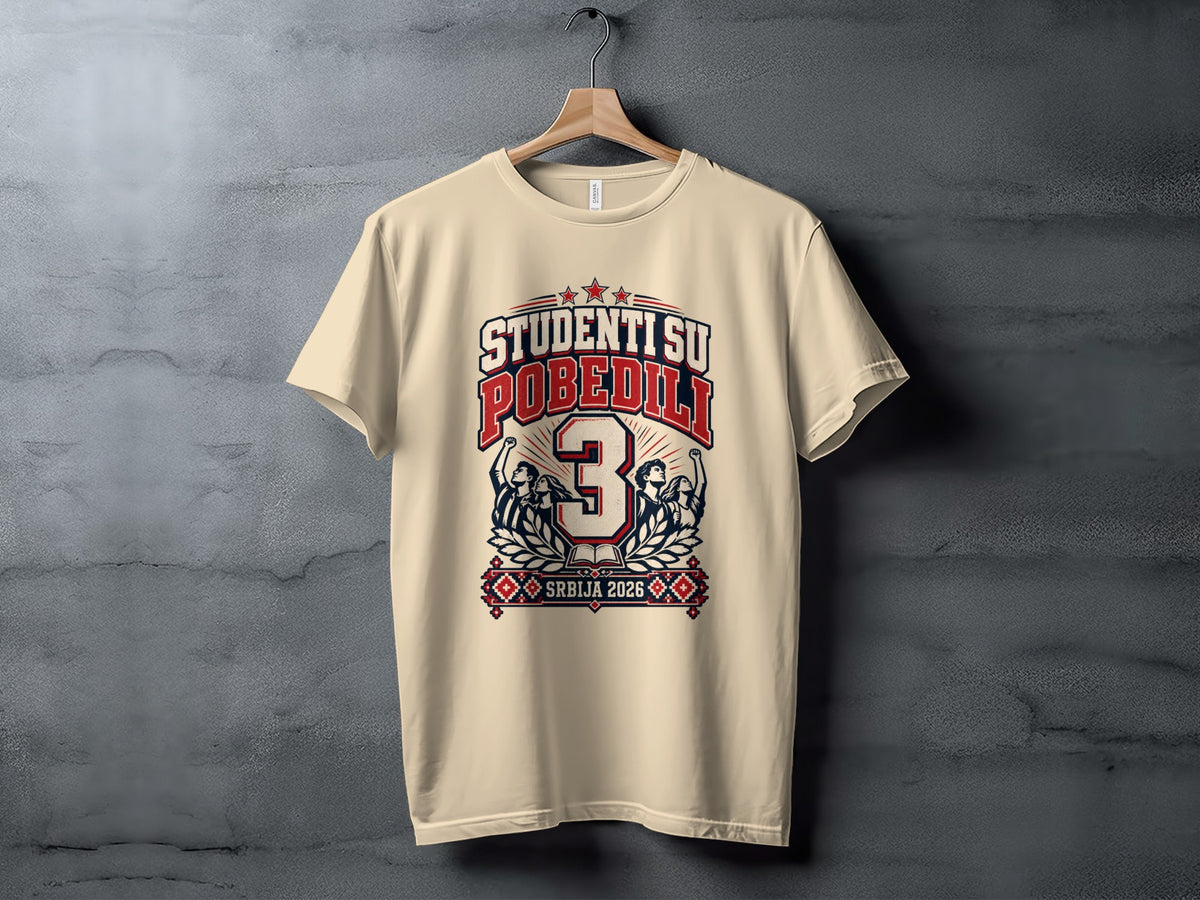 A cream-colored t-shirt hangs on a wooden hanger against a gray textured wall, featuring Serbian political graphic print.