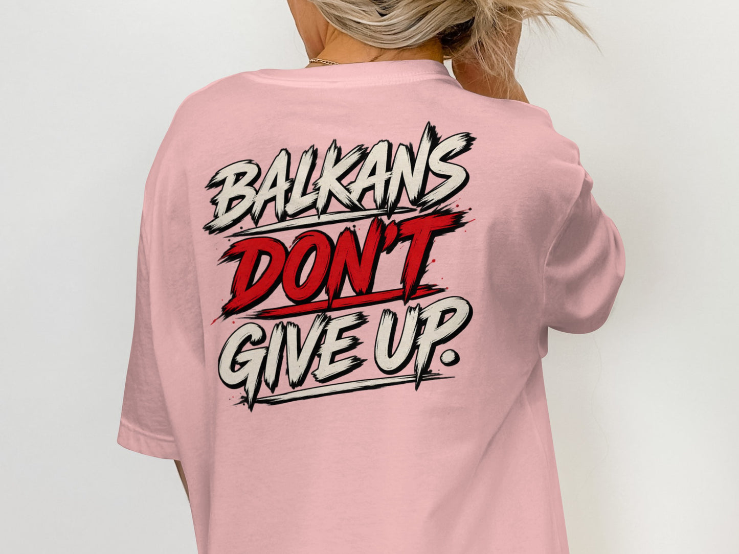 Pink t-shirt with "BALKANS DON'T GIVE UP." graphic on back