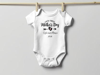 White baby onesie with "Our First Mother's Day Sofia and Mama 2026" text.