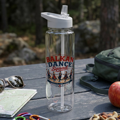 Clear water bottle with "Balkan Dance Squad" text and dancers, on a table with snacks.
