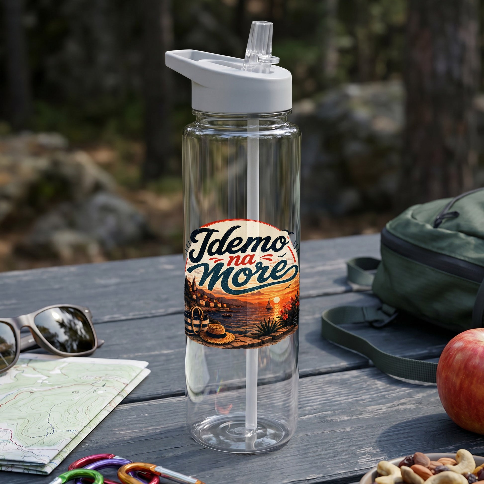 Clear water bottle with vacation-themed "Idemo na More" graphic on a table.