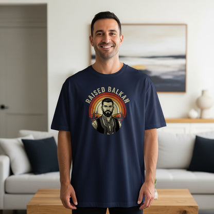 Navy t-shirt with a circular vintage design featuring a man and text "RAISED BALKAN".