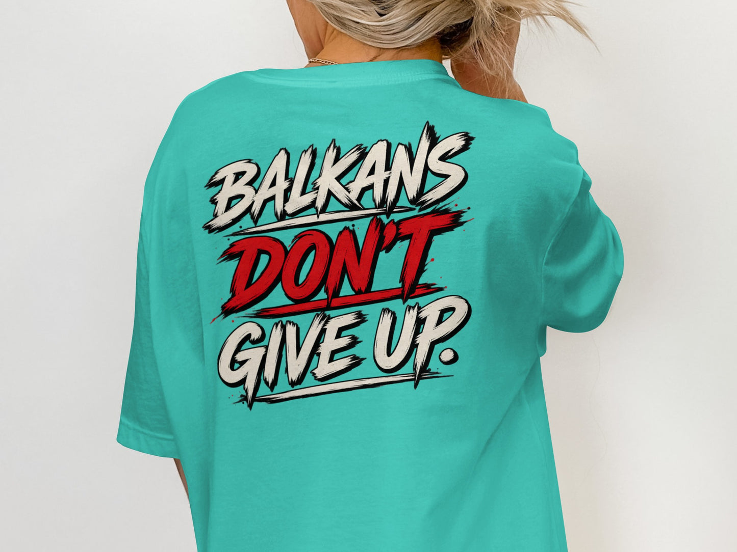 Turquoise t-shirt with "Balkans Don't Give Up" text design on back.
