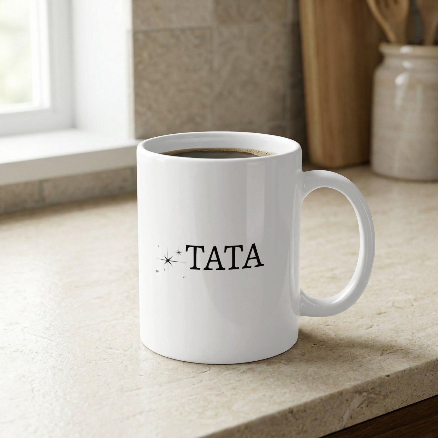 White mug with "TATA" in black text and small star accents.