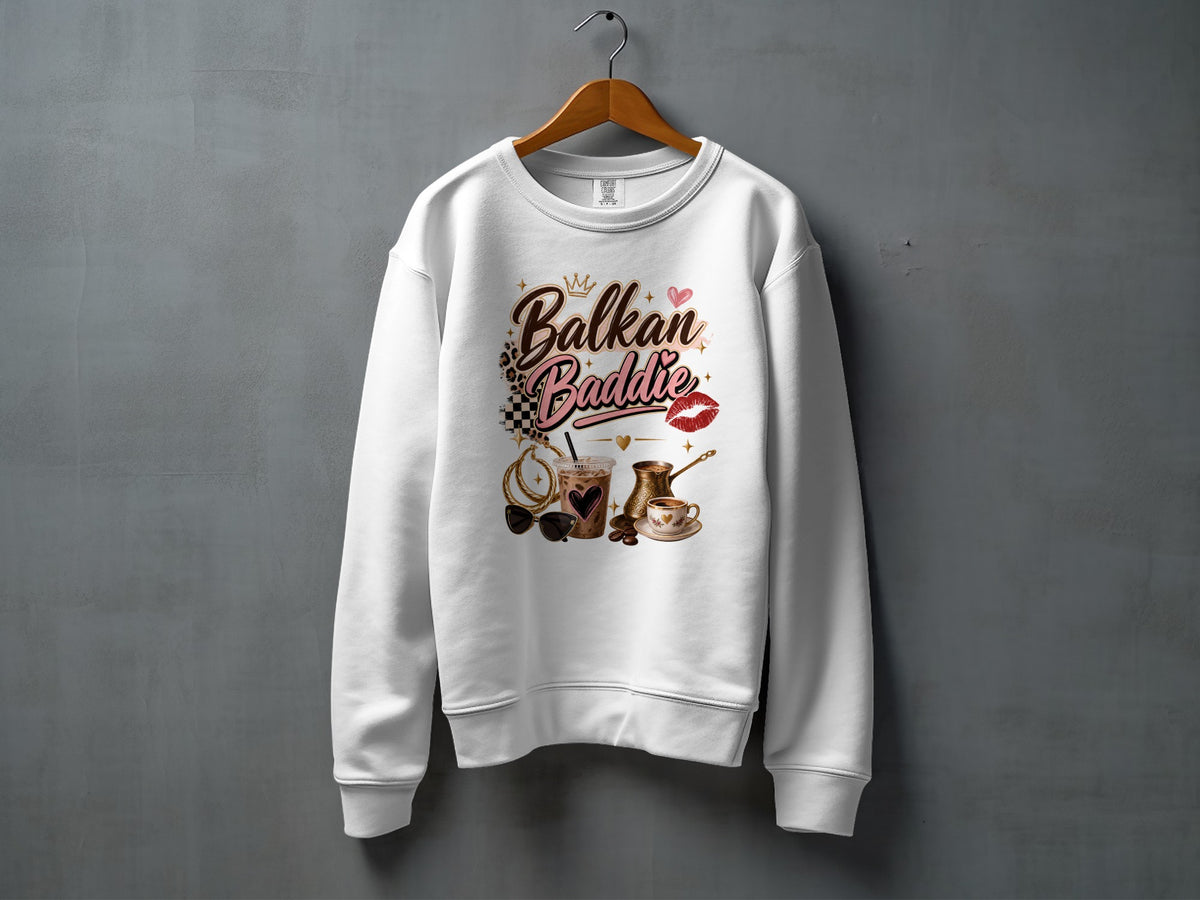 White sweatshirt with "Balkan Baddie" text and graphic elements of coffee, sunglasses, and lipstick.