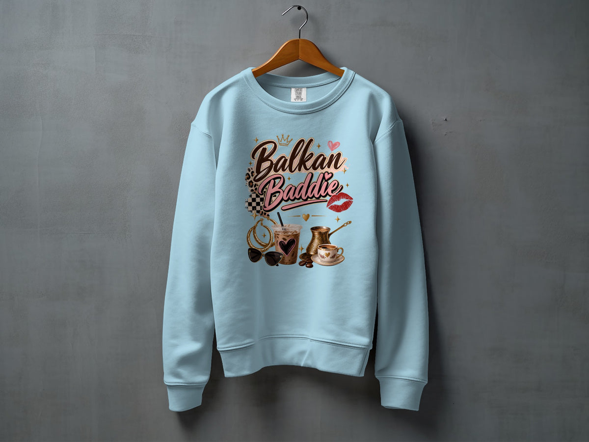 Light blue sweatshirt with "Balkan Baddie" text and coffee, sunglasses, and jewelry graphics.